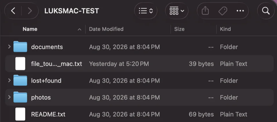 A Finder list view of the mounted LUKSMAC-TEST volume: the folders documents, lost+found and photos beside README.txt and other text files, in Name / Date Modified / Size / Kind columns.